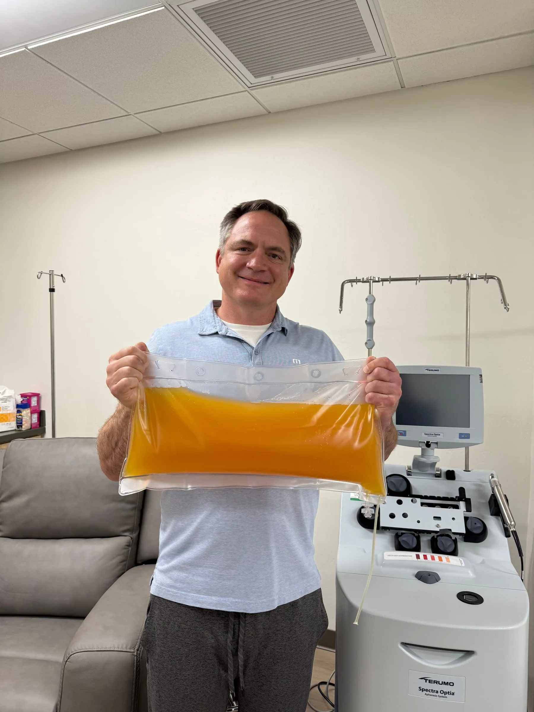 Avinity Health patient holding his bag right after a therapeutic plasma exchange (TPE) session — the classic post-treatment photo.