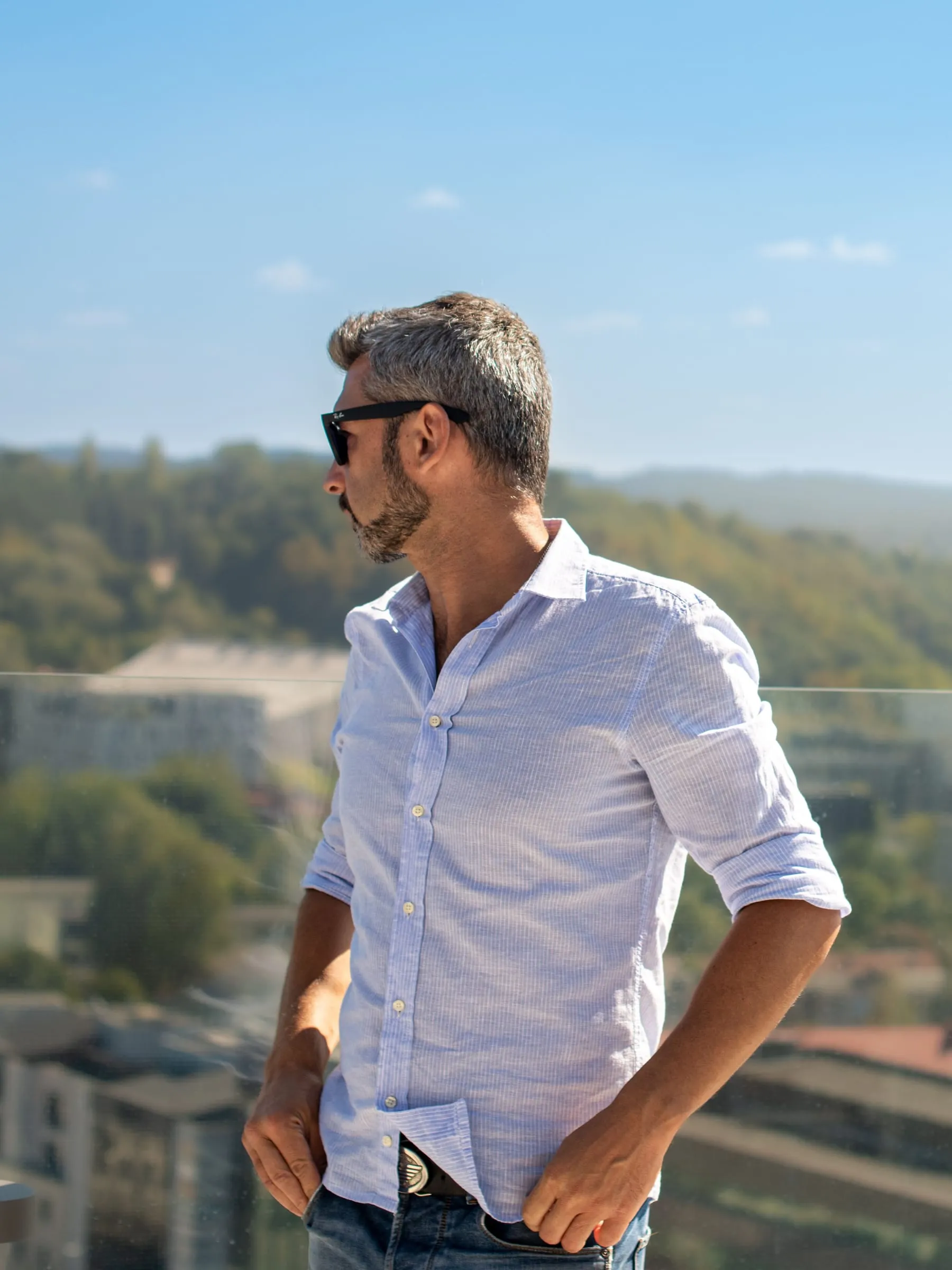 Healthy middle-aged man with graying hair standing outdoors in the sun