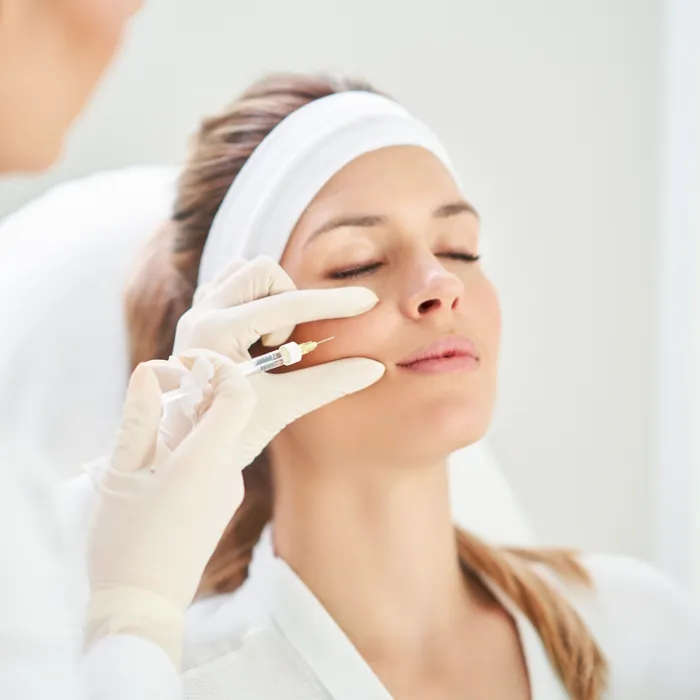Botox injection near the cheek performed by a gloved practitioner at Avinity Health
