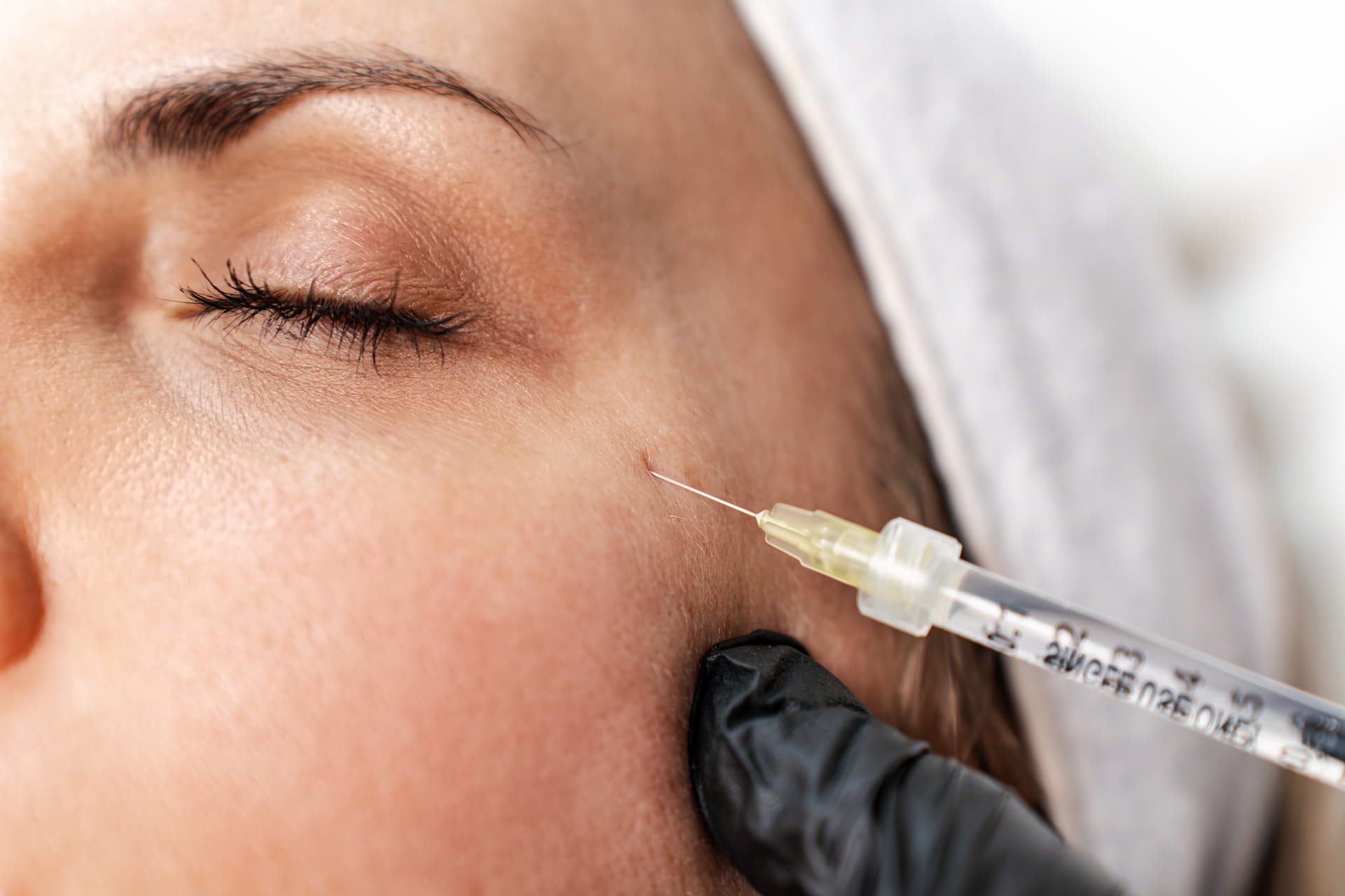 Botox injection near cheek by gloved practitioner at Avinity Health