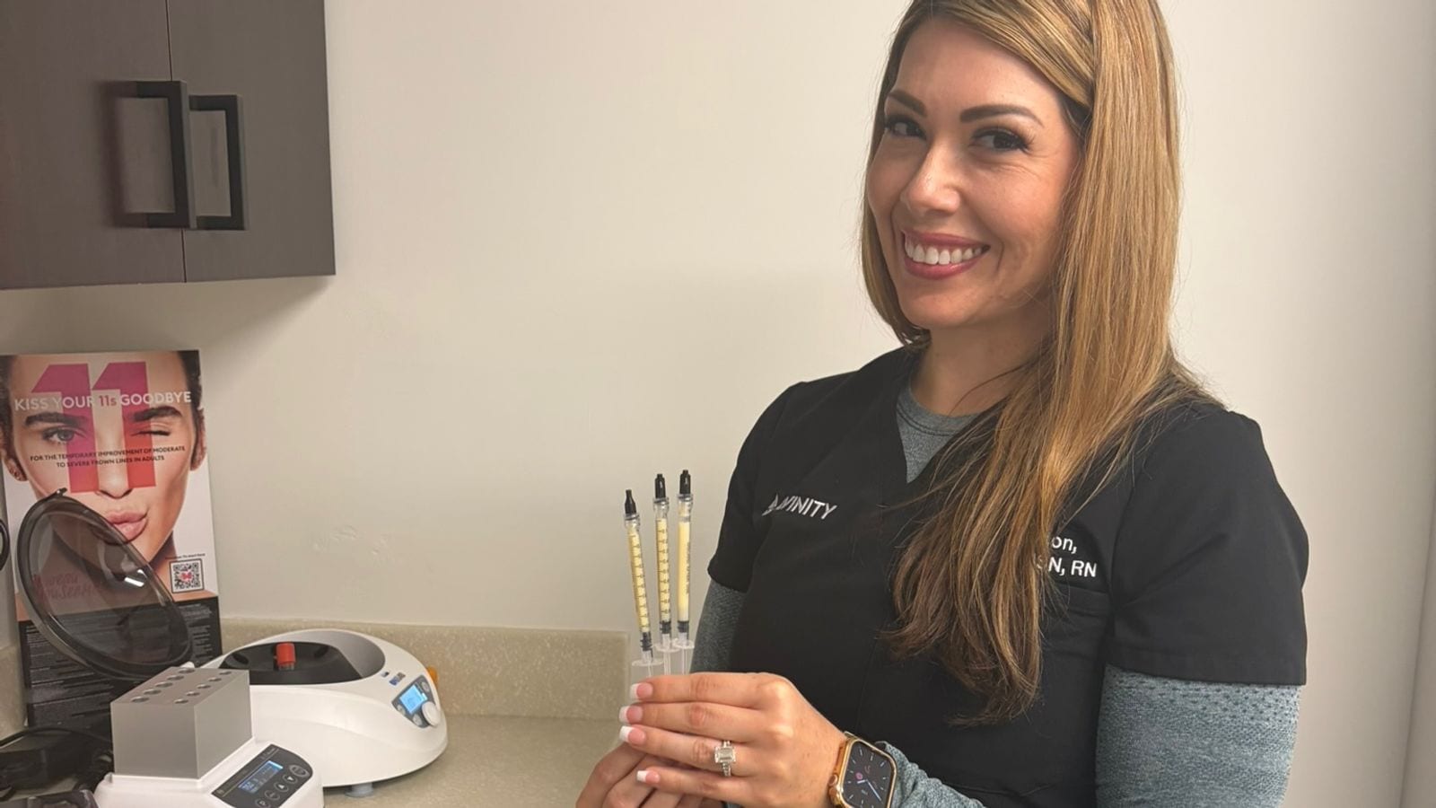 An Avinity Health registered nurse in Scottsdale holding prepared plasma gel syringes beside the centrifuge and heater used to make Selphyller Gel.